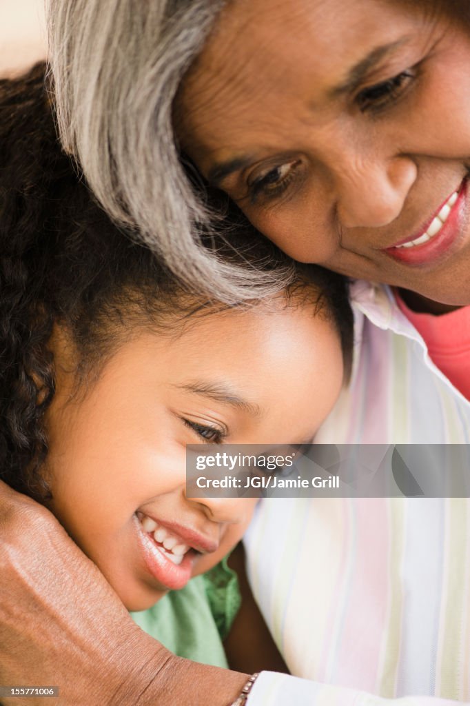 African American grandmother and granddaughter hugging