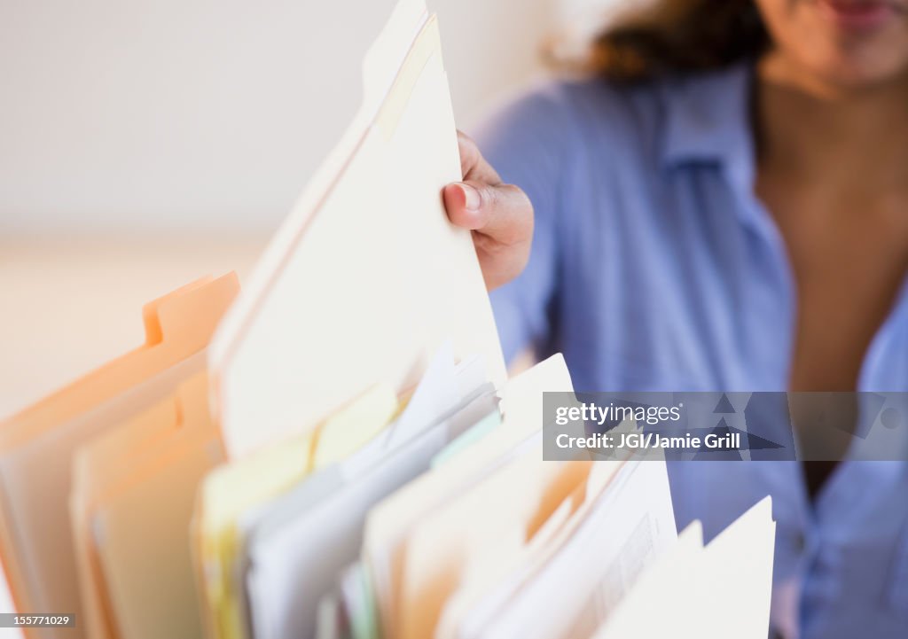 Cape Verdean woman picking up file folder