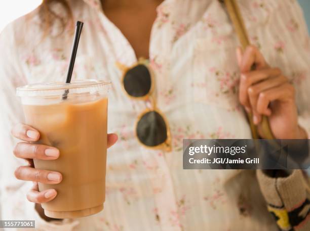 cape verdean woman drinking iced coffee - iced coffee stock-fotos und bilder