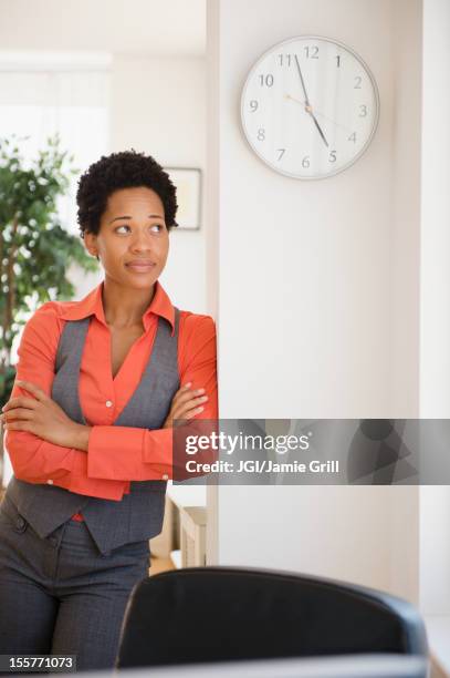 impatient african american businesswoman leaning against wall - la tarde fotografías e imágenes de stock