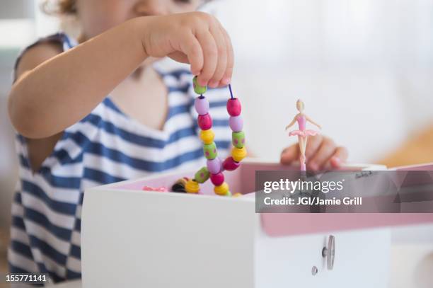 mixed race girl taking jewelry from jewelry box - music box stock pictures, royalty-free photos & images