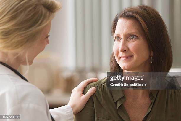 doctora hablando con el paciente - mujeres de mediana edad fotografías e imágenes de stock
