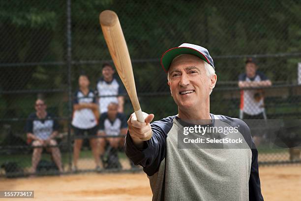 senior man holding baseball bat - home run concept stock pictures, royalty-free photos & images