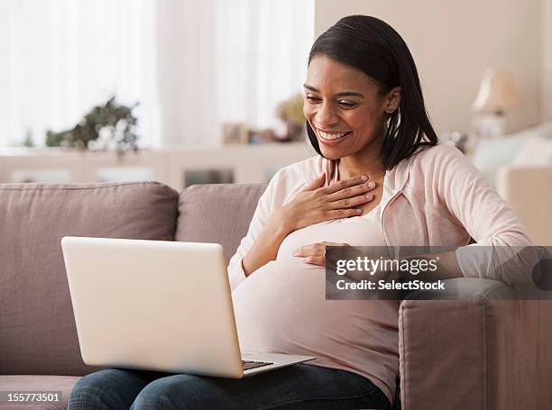 schwangere frau sitzt auf laptop - west new york new jersey stock-fotos und bilder