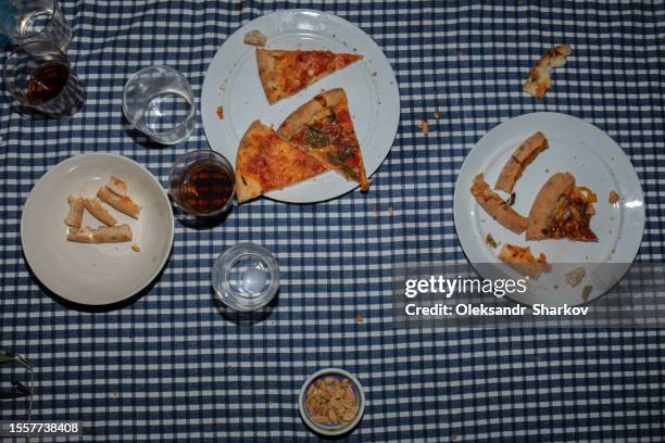 leftover pizza on the table after the party - messy table after party - fotografias e filmes do acervo