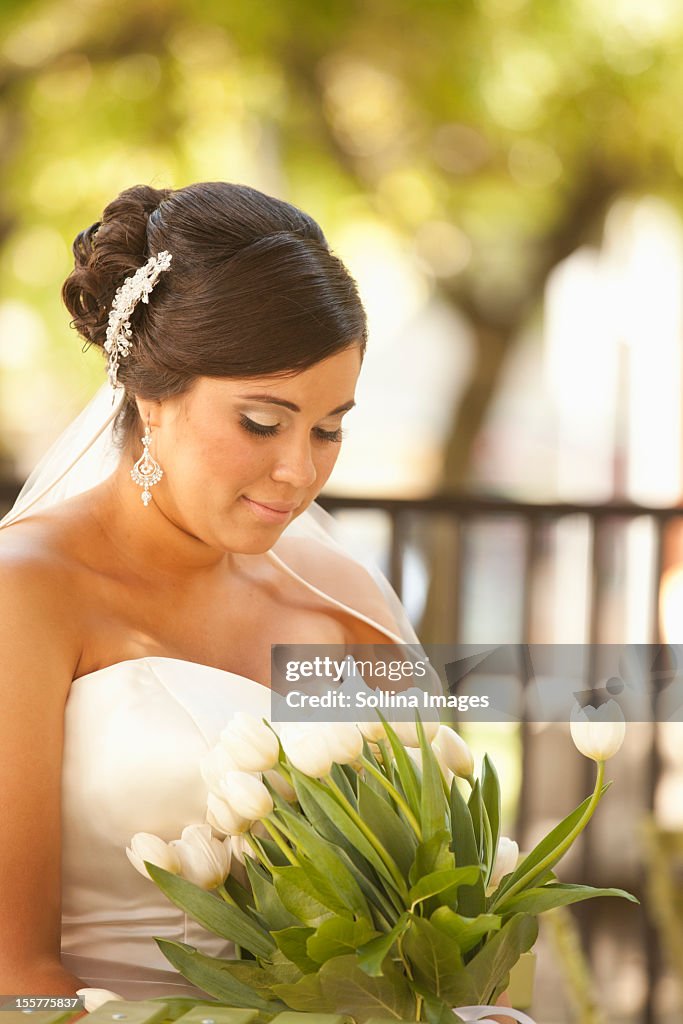 Hispanic bride holding bouquet