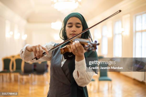 muslim female violin practice in school - classical orchestral music stock pictures, royalty-free photos & images