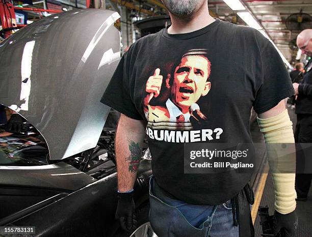 Ford worker stands on the assembly line where gasoline-powered, electric, hybrid and plug-in hybrid vehicles are produced at the Michigan Assembly...