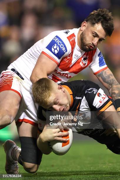 Alex Seyfarth of the Tigers is tackled by Jack Bird of the Dragons during the round 21 NRL match between St George Illawarra Dragons and Wests Tigers...