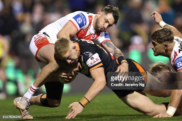 Alex Seyfarth of the Tigers is tackled by Jack Bird of the Dragons during the round 21 NRL match between St George Illawarra Dragons and Wests Tigers...