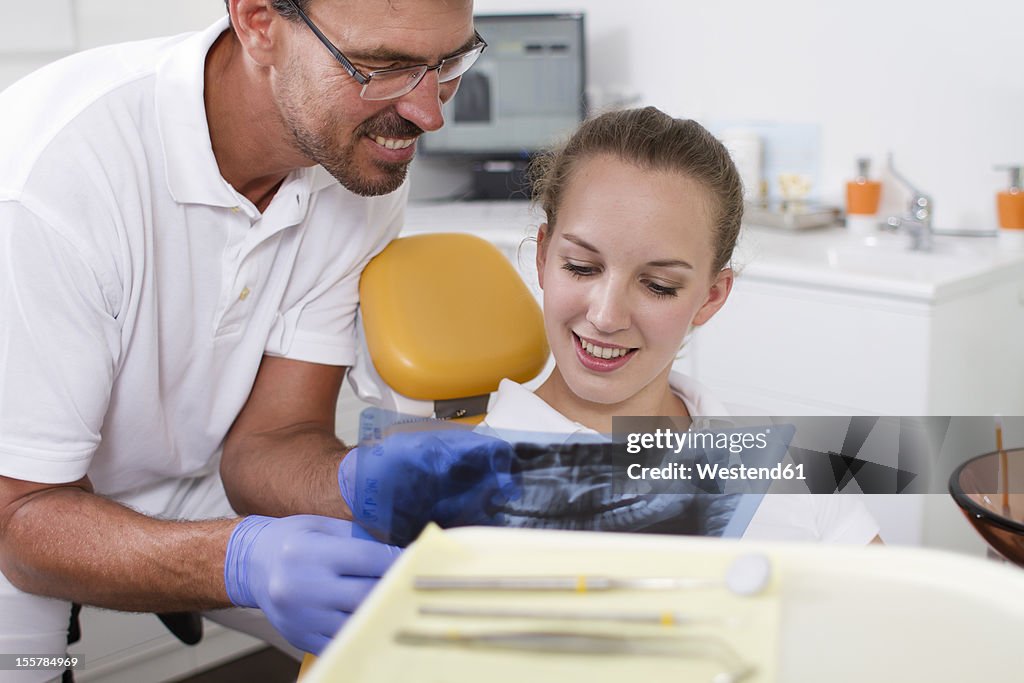 Germany, Brandenburg, Strausberg, Dentist explaining x ray picture to patient