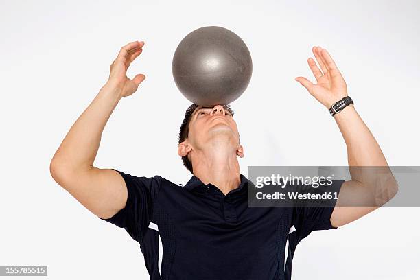 personal trainer balancing ball on forehead, close up - trainer cutout stockfoto's en -beelden