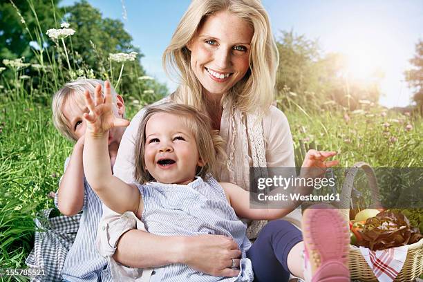 germany, cologne, family sitting on blanket at picnic, smiling - 4 life natural foods stock-fotos und bilder