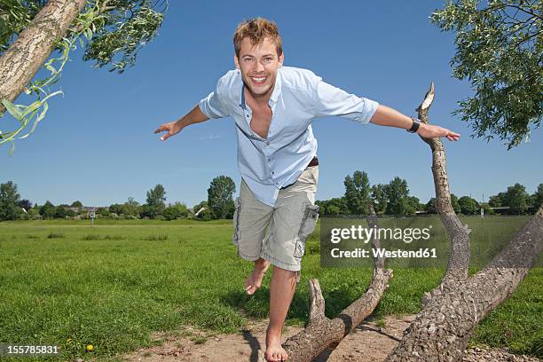 germany, north rhine westphalia, duesseldorf, mid adult man playing with tree, smiling, portrait - 飛行機のまね ストックフォトと画像
