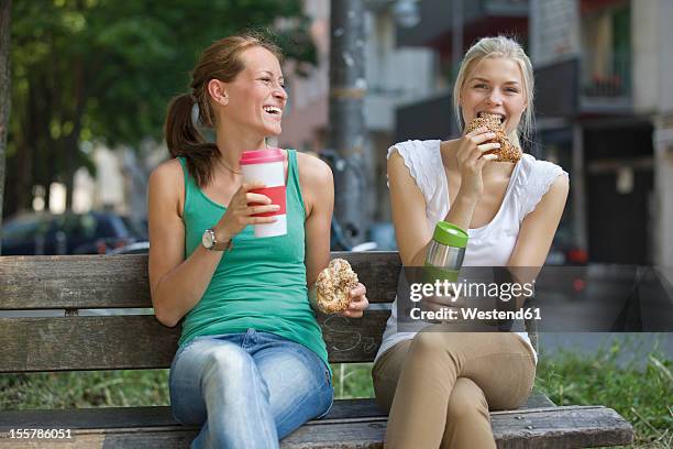 germany, north rhine westphalia, cologne, young women sitting on bench with coffee and croissants - 2 cup of coffee stock pictures, royalty-free photos & images