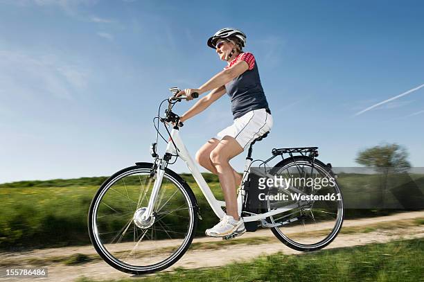 germany, bavaria, mature woman riding electric bicycle - cycling shorts stock pictures, royalty-free photos & images