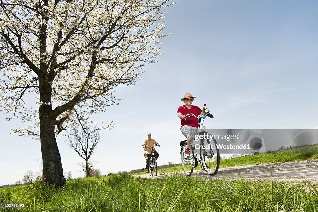 Germany, Bavaria, Senior couple riding electric bicycle