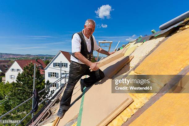 germany, baden-wuerttemberg, stuttgart, mature man placing insulation - insulation stock pictures, royalty-free photos & images