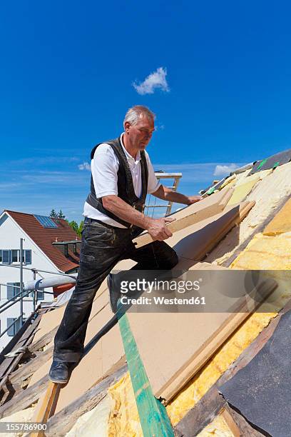 germany, baden-wuerttemberg, stuttgart, mature man placing insulation - house insulation not posing stockfoto's en -beelden