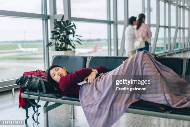 woman resting in aiport terminal - kuala lumpur airport stockfoto's en -beelden