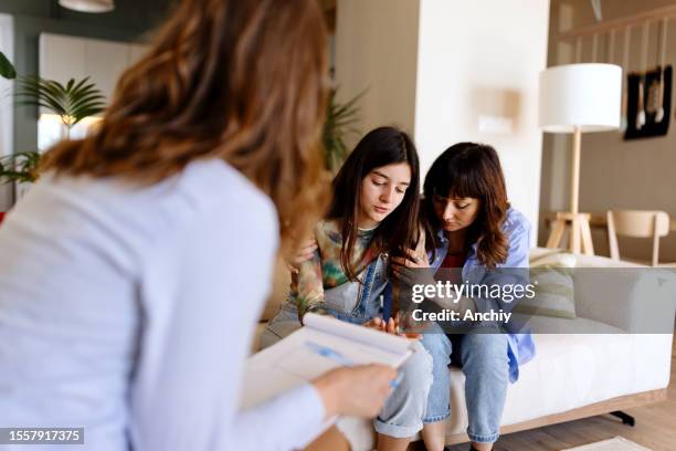 mother and a daughter talking with a psychotherapist - teenage pregnancy stock pictures, royalty-free photos & images