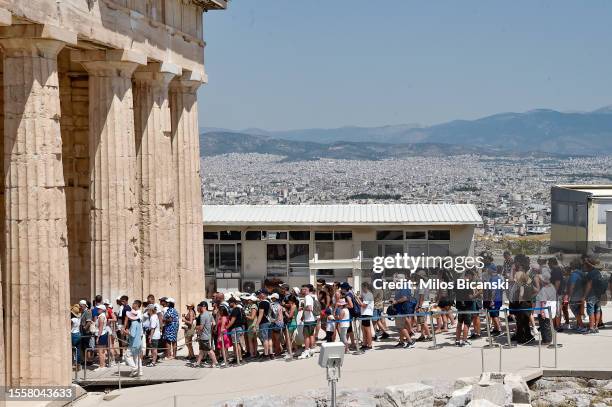 Tourists queue at the Acropolis, Parthenon temple during a heat wave on July 20, 2023 in Athens, Greece. The Acropolis of Athens and other...