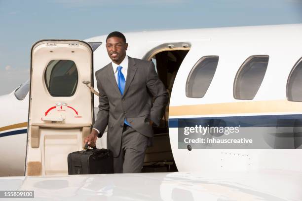 businessman standing outside of corporate jet - jet tarmac stock pictures, royalty-free photos & images