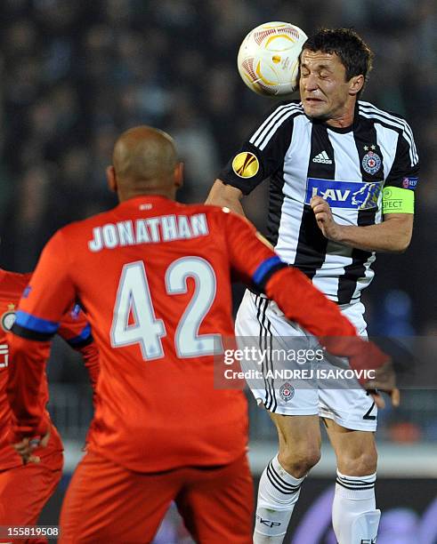 Partizan Belgrade's Sasa Ilic heads the ball in front of Inter Milan's Jonathan during the UEFA Europa League group H football match Partizan...