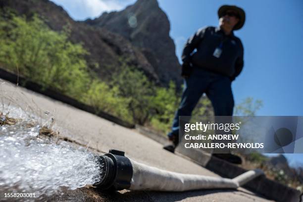 Steve Paz, a volunteer with the Arizona Game and Fish Department, looks on as water is pumped into wildlife water catchment 489 in Green Valley,...