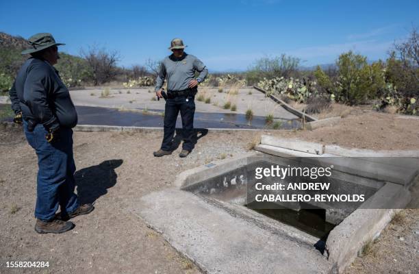 Steve Paz, a volunteer with the Arizona Game and Fish Department, and Wildlife Manager Brian Aragon look on as water is pumped to wildlife water...