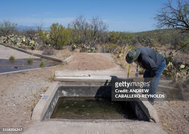 Steve Paz, a volunteer with the Arizona Game and Fish Department, checks the levels of wildlife water catchment 489 in Green Valley, Arizona, 42...
