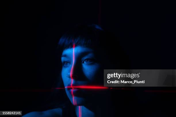 portrait of young woman illuminated neon light and laser - cruz forma imagens e fotografias de stock
