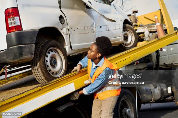 female towing operator managing vehicle on flatbed truck - truck and car accident stock pictures, royalty-free photos & images