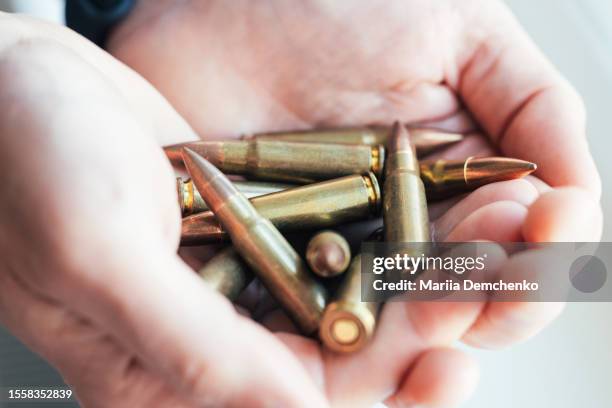 cartridges for kalashnikov assault rifle in male hands - bala munición fotografías e imágenes de stock