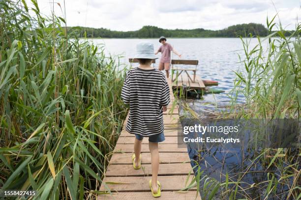 young boy on a pier near lake - 11 loch stock pictures, royalty-free photos & images