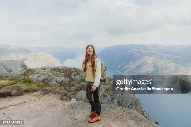 happy woman backpacker admiring view of idyllic lysefjord from above in norway - health motivational quotes stock pictures, royalty-free photos & images
