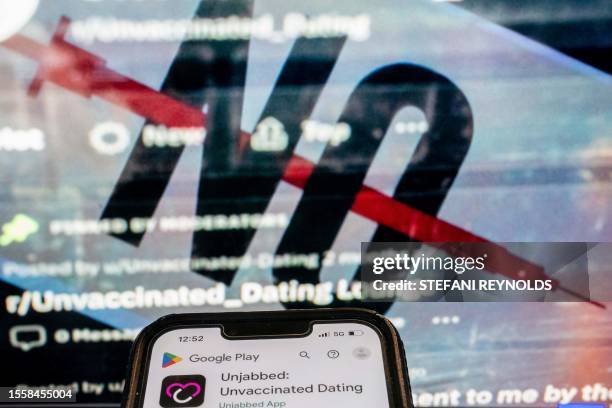 This photo illustration created in Washington, DC, on July 26 shows the "Unjabbed: Unvaccinated Dating" app in front of the cover image of a Facebook...