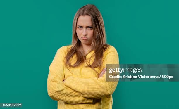 offended young woman crossing arms with turquoise hair standing against turquoise background - editorial template stock pictures, royalty-free photos & images