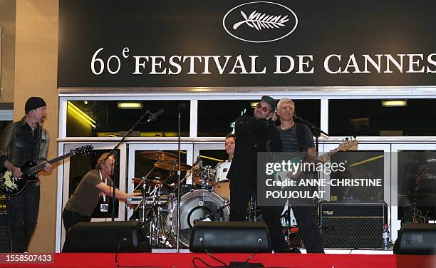 Irish rock band U2 lead singer Bono performs early 20 May 2007 with fellow band members British guitar player The Edge , Irish drummer Larry Mullen...