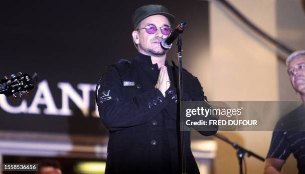 Irish rock band U2's lead singer Bono performs early 20 May 2007 with fellow band member British bass player Adam Clayton on the red carpet at the...