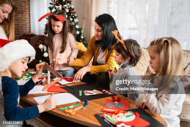 family making christmas greeting cards at home - child cutting card stock pictures, royalty-free photos & images