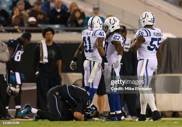 Blaine Gabbert of the Jacksonville Jaguars is knocked out of the game after a play by Antoine Bethea, Justin Hickman and Josh Gordy of the...