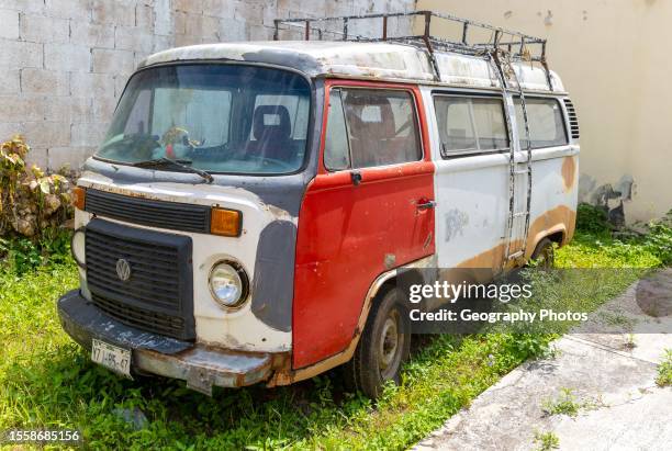 Old rusty VW Volkswagen camper van in garden, Vallodolid, Yucatan, Mexico.