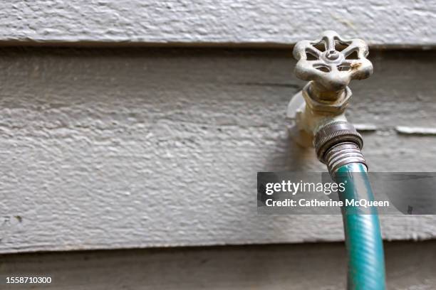 traditional outdoor faucet spigot or hose bibb & garden hose on house exterior siding - hose stock pictures, royalty-free photos & images