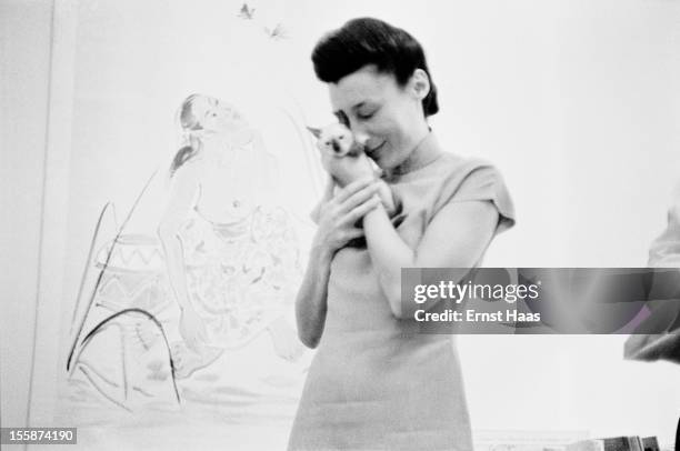 Chinese-born writer and physician Han Suyin holding a kitten, circa 1960.