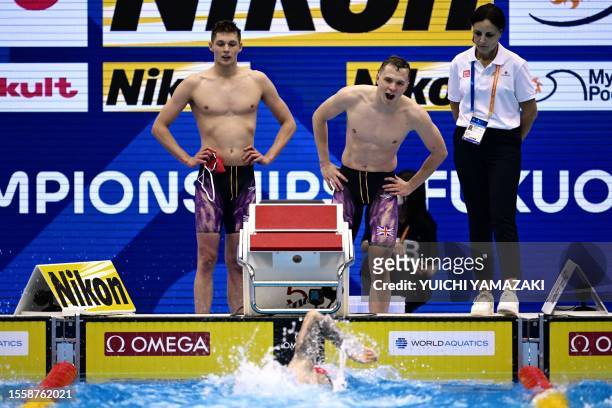 Britain's Matthew Richards competes as teammates look on in a heat of the men's 4x200m freestyle relay swimming event during the World Aquatics...