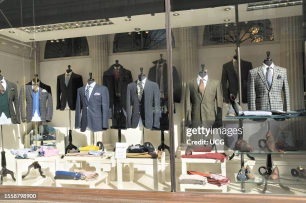 Mens suit jackets and formalwear in a shop window display in central London.