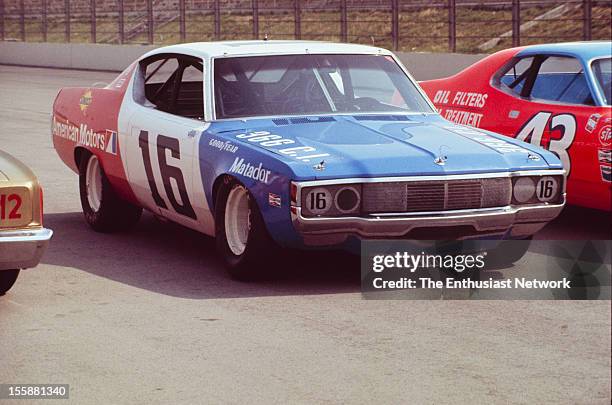 Miller 500 - NASCAR - Ontario Motor Speedway. Mark Donohue of Penske racing AMC Matador sits parked on track between the car of Richard Petty and...