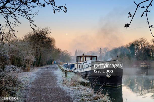 View from Abingdon Weir downstream of the River Thames, foggy winter morning and majestic Wolf Moon.