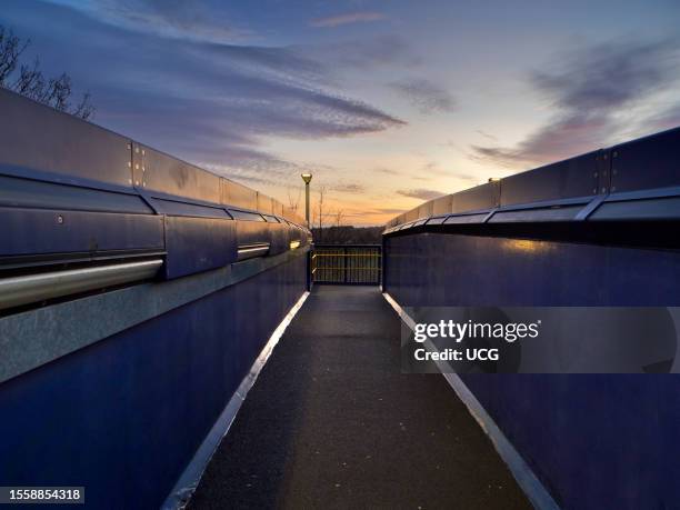 Elevated walkway over the tracks at Radley Railway Station, vivid winter pre-dawn.